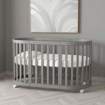 Lettino rotondo per neonati affiancabile al letto Mikko Gekko 140x70. Crescente – disponibile la funzione di trasformazione. Può essere dotata di ruote oppure di meccanismo a dondolo per cullare il bambino. Colore grigio